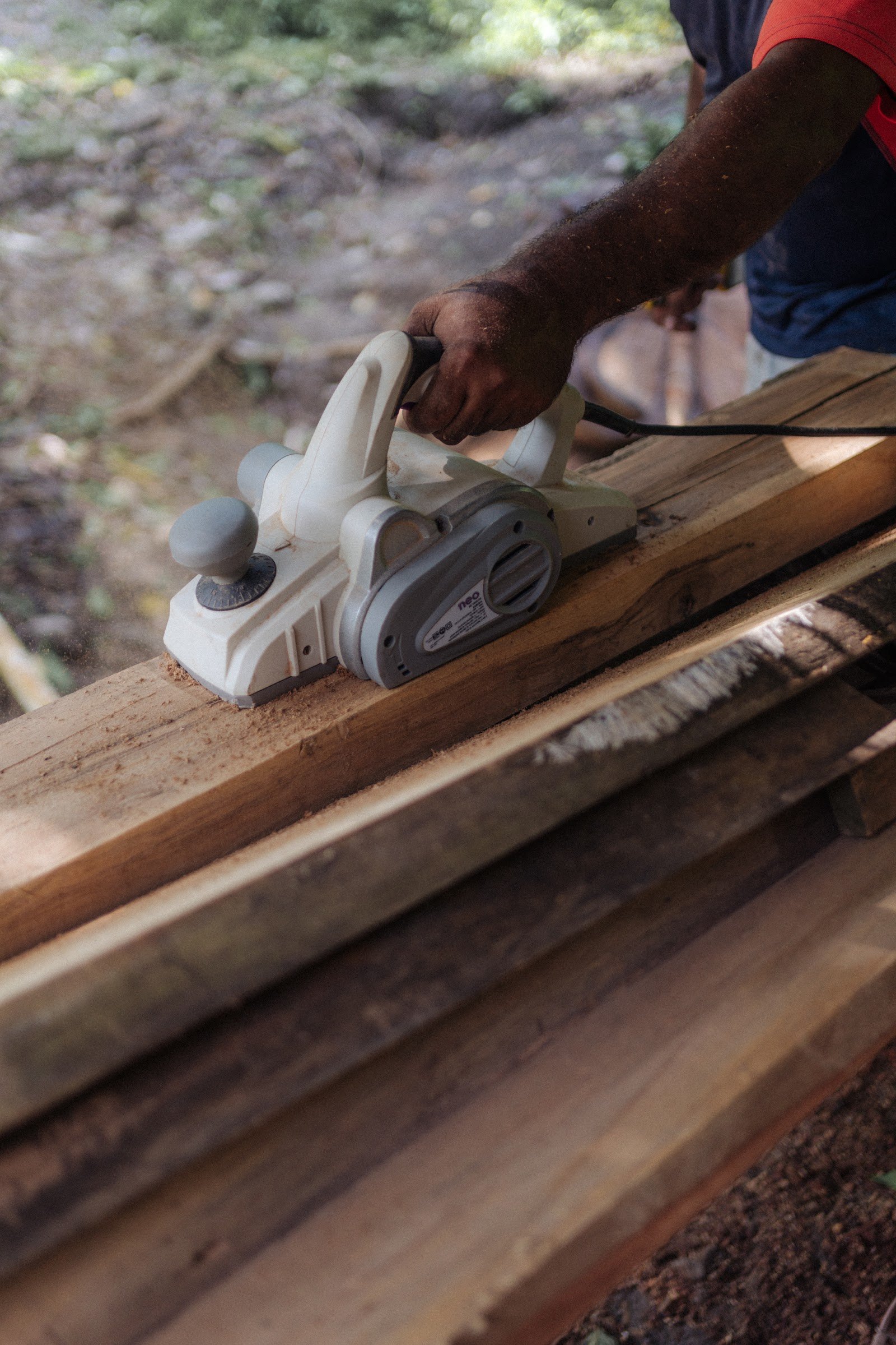 Hands planing wood at the Casa Nana woodshop
